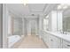 Bright bathroom with a bathtub, a large glass shower, double sinks, and a large walk-in closet space at 6366 Lineberry Rd, Liberty, NC 27298