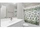 Well-lit bathroom with white vanity, floral shower curtain, and bathtub at 6366 Lineberry Rd, Liberty, NC 27298