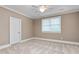This bedroom features neutral carpet, a ceiling fan, and a view of the backyard at 6366 Lineberry Rd, Liberty, NC 27298