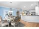 A formal dining room is furnished with a wooden table that's set for dinner and has a view into the kitchen at 6366 Lineberry Rd, Liberty, NC 27298