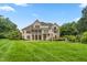 Spacious backyard view of a brick home, large lawn, screened porch and stairwell leading to yard at 6366 Lineberry Rd, Liberty, NC 27298