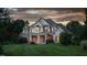 Beautiful exterior view of a brick home with manicured lawn, mature trees, and sunset sky at 6366 Lineberry Rd, Liberty, NC 27298