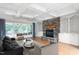 Spacious living room boasts a stone fireplace, hardwood floors, built-in shelves, and coffered ceilings at 6366 Lineberry Rd, Liberty, NC 27298