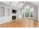 Bright living room featuring hardwood floors, built-in shelves, and large windows at 6366 Lineberry Rd, Liberty, NC 27298