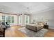 A spacious main bedroom with tray ceilings, large windows, hardwood floors, a ceiling fan, and stylish decor at 6366 Lineberry Rd, Liberty, NC 27298