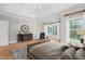 Main bedroom featuring neutral walls, hardwood floors, a tray ceiling, and windows overlooking the outdoors at 6366 Lineberry Rd, Liberty, NC 27298