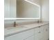 Modern bathroom features dual sinks, sleek white cabinetry and an illuminated mirror at 1533 Urban Trace Ln, Raleigh, NC 27608