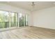 This bedroom has a ceiling fan, light hardwood floors, and sliding doors that open to a balcony at 1533 Urban Trace Ln, Raleigh, NC 27608