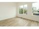 Bright bedroom with light hardwood floors and large windows offering backyard views at 1533 Urban Trace Ln, Raleigh, NC 27608