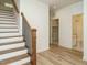 Inviting entryway with hardwood floors, wooden staircase, and views into the bathroom and laundry room at 1533 Urban Trace Ln, Raleigh, NC 27608