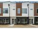 Modern townhome exterior featuring a brick facade, wood and white siding, and contemporary design at 1533 Urban Trace Ln, Raleigh, NC 27608