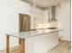 Bright kitchen with stainless steel appliances, white cabinetry, and island with wood trim at 1533 Urban Trace Ln, Raleigh, NC 27608