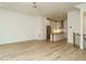 Spacious open-concept living room with light hardwood floors leading to a modern kitchen and stairs at 1533 Urban Trace Ln, Raleigh, NC 27608