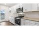 Well-lit kitchen with stainless steel appliances, white cabinets, and granite countertops at 791 Washington St, Fuquay Varina, NC 27526