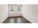Bedroom with wood-look floors, light walls, and two windows with blinds at 802 Dorset Stream Dr, Fuquay Varina, NC 27526