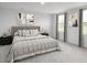 Calm bedroom with a tufted headboard, neutral bedding, dark nightstands, and natural light through windows at 331 Tormore Dr, Sanford, NC 27330