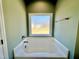 Bright bathroom showcasing a bathtub with frosted window at 144 Emerson Fields Dr, Pikeville, NC 27863