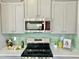 Bright kitchen features gray cabinets, stainless steel appliances, and a striking backsplash at 144 Emerson Fields Dr, Pikeville, NC 27863