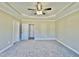 Spacious primary bedroom with neutral carpet, a tray ceiling, and multiple closets at 144 Emerson Fields Dr, Pikeville, NC 27863