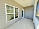Side view of a screened porch featuring a door, windows, and tan siding at 144 Emerson Fields Dr, Pikeville, NC 27863