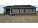 Rear exterior with gray siding and a screened-in porch overlooking the backyard at 144 Emerson Fields Dr, Pikeville, NC 27863