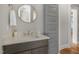 Neutral bathroom with wood vanity cabinet, granite countertop, round mirror, and chrome faucet at 210 Colvard Farms Rd, Durham, NC 27713