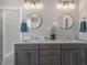 Bathroom featuring double sinks, stone countertop and round mirrors at 210 Colvard Farms Rd, Durham, NC 27713