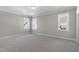 Spacious bedroom with three windows, gray walls, white trim, and neutral carpet at 210 Colvard Farms Rd, Durham, NC 27713