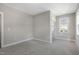 Bedroom with neutral carpet, white trim, gray paint, and a large window with natural light at 210 Colvard Farms Rd, Durham, NC 27713
