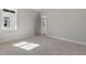 Bright bedroom featuring neutral carpet, gray walls, a window, and an open door at 210 Colvard Farms Rd, Durham, NC 27713