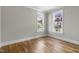 Bedroom with neutral paint, hardwood flooring, white trim and two windows at 210 Colvard Farms Rd, Durham, NC 27713
