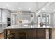 Bright kitchen featuring a center island with stone countertop, pendant lights, and ample cabinetry at 210 Colvard Farms Rd, Durham, NC 27713