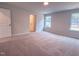 An expansive bedroom with plush carpeting, two windows, and a glimpse into the ensuite bathroom at 439 Duncan Creek Rd # 140, Lillington, NC 27546