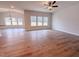 Bright living room boasts wood floors, large windows, and a modern ceiling fan at 439 Duncan Creek Rd # 140, Lillington, NC 27546