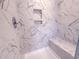 Detailed view of the marble-tiled shower, bench, and convenient in-wall niches at 439 Duncan Creek Rd # 140, Lillington, NC 27546