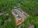 Aerial view showcases newly constructed townhouses with black roofs, surrounded by dense green forests at 6402 Tanner Oak Ln, Raleigh, NC 27613