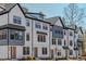 Modern townhouse complex showcasing white siding, black trim, and well-manicured landscaping at 6402 Tanner Oak Ln, Raleigh, NC 27613