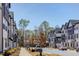 A wide street lined with modern, two-story townhouses and lush, green trees at 6402 Tanner Oak Ln, Raleigh, NC 27613