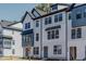 Charming three-story townhome featuring Hardie siding, black window accents, and an inviting entryway at 6408 Tanner Oak Ln, Raleigh, NC 27613