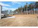 Expansive backyard featuring tall trees, a covered porch, and ample outdoor space for recreation at 130 Bold Dr, Youngsville, NC 27596