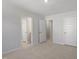 Neutral bedroom with carpet flooring, multiple doorways, and a modern, minimalist design at 130 Bold Dr, Youngsville, NC 27596