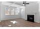Well-lit living room featuring a fireplace, large windows, trey ceiling and wood-look flooring at 130 Bold Dr, Youngsville, NC 27596