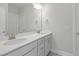 Bathroom featuring double sinks with gray cabinets, white countertops, a large mirror, and modern lighting at 413 Edison Rail Ln, Knightdale, NC 27545