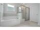 Bathroom featuring a soaking tub and a separate glass-enclosed shower at 413 Edison Rail Ln, Knightdale, NC 27545