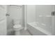 Bathroom featuring toilet and tub with shower, white trim, and tiled floors at 413 Edison Rail Ln, Knightdale, NC 27545