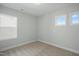Bedroom featuring neutral carpet, white trim, grey walls, and two windows at 413 Edison Rail Ln, Knightdale, NC 27545