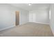 Spacious bedroom featuring neutral carpet, white walls, and a double-door closet, illuminated by a ceiling light at 413 Edison Rail Ln, Knightdale, NC 27545