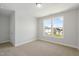 Bedroom featuring neutral carpet, grey walls, white trim, and a window view at 413 Edison Rail Ln, Knightdale, NC 27545