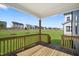 Covered deck with wooden railings overlooking large backyard at 413 Edison Rail Ln, Knightdale, NC 27545