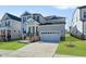 Inviting two-story home with gray siding, complemented by a well-kept lawn and a two-car garage at 413 Edison Rail Ln, Knightdale, NC 27545